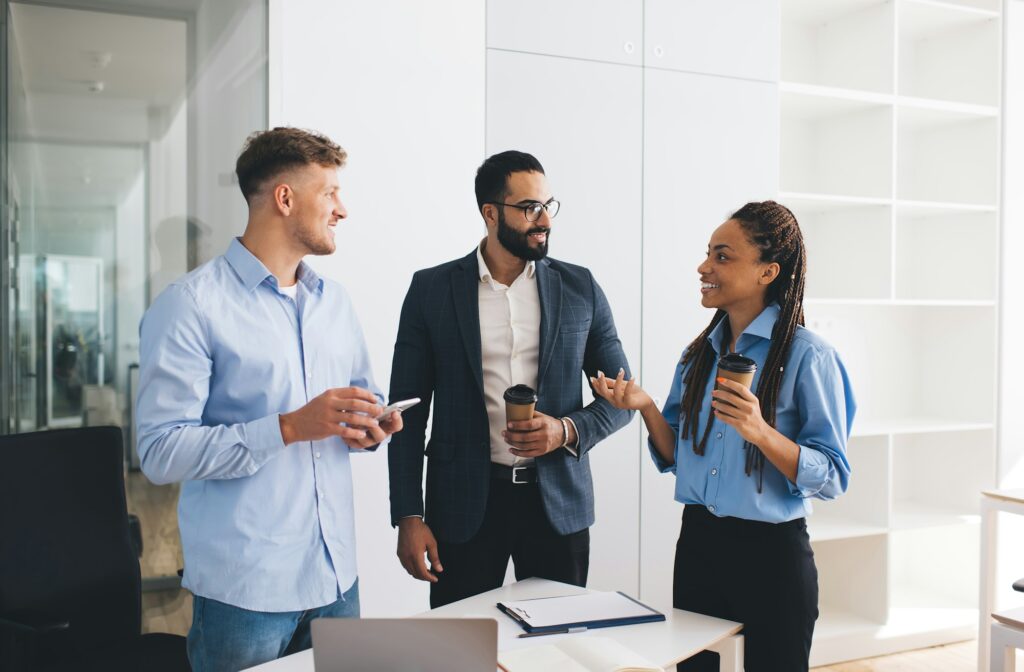 Happy group of professionals in formal wear discussing business during briefing in office